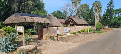a house with a thatch roof on the side of a road at Xisaka Guest House in Giyani
