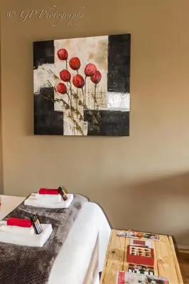 a room with two beds and a painting on the wall at Laguna Lodge in Graskop