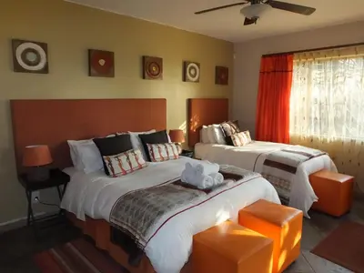 a hotel room with two beds and a window at Tatenda Guest House in Hazyview