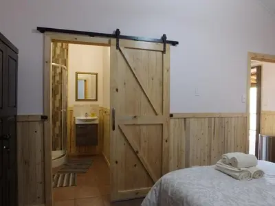 a bedroom with a sliding barn door and a bed at Tatenda Guest House in Hazyview