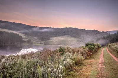 a dirt road next to a body of water at Pavetta Country House in Magoebaskloof