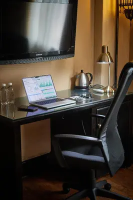 a laptop computer sitting on a desk with a chair at Tayfin Royale Hotel & Conference Centre in Centurion
