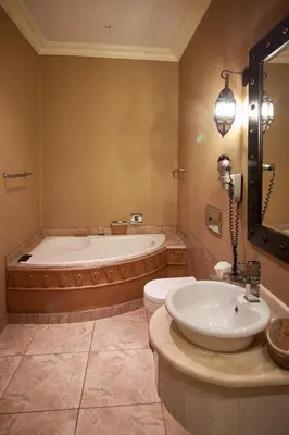 a bathroom with a tub and a toilet and a sink at Tayfin Royale Hotel & Conference Centre in Centurion
