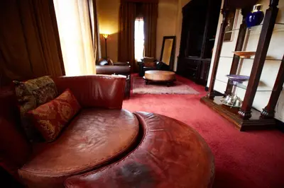 a living room with a brown leather couch in a room at Tayfin Royale Hotel & Conference Centre in Centurion