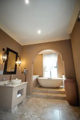 a bathroom with two sinks and a tub and a window at Tayfin Royale Hotel & Conference Centre in Centurion