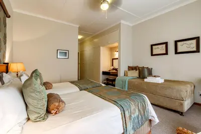 a hotel room with two beds and a couch at Porcupine Ridge Guest House in Sabie