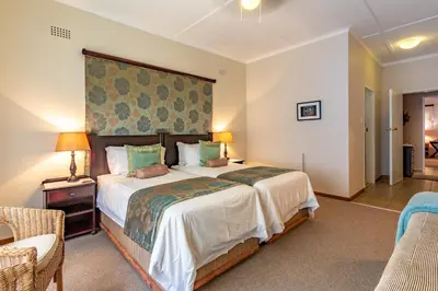 a bedroom with a large bed with a large headboard at Porcupine Ridge Guest House in Sabie