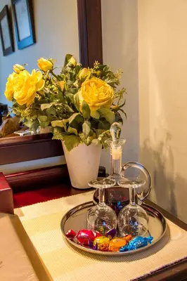 a tray with glasses and a vase with yellow roses at Porcupine Ridge Guest House in Sabie