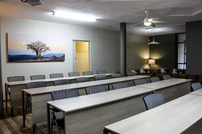a waiting room with rows of tables and chairs at Polo Guest House in Polokwane