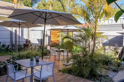 a patio with tables and chairs and umbrellas at Polo Guest House in Polokwane