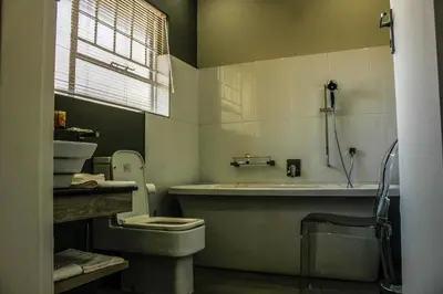 a bathroom with a tub and a toilet and a sink at Polo Guest House in Polokwane