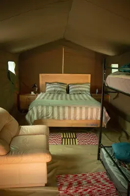 a bedroom with a bed and a couch in a room at Shik Shack Backpackers in Guernsey Nature Reserve