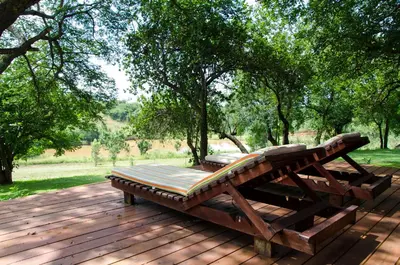a wooden bench sitting on a wooden deck at Villa Rostrata-on-Lake in Hazyview