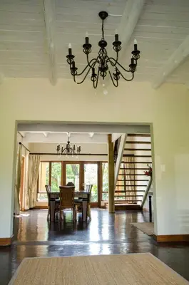 a dining room with a table and a chandelier at Villa Rostrata-on-Lake in Hazyview