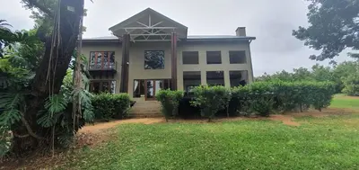 a large house with a porch and a yard at Villa Rostrata-on-Lake in Hazyview