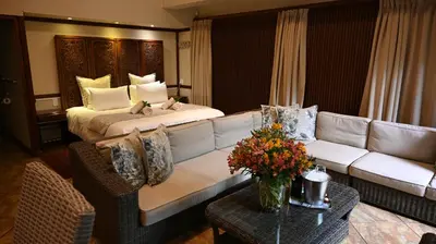 a hotel room with a couch and a bed at Lamor Guest House in Middelburg