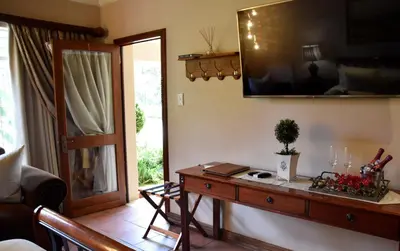 a living room with a table and a mirror at Lamor Guest House in Middelburg
