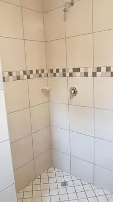 a bathroom with a shower with a tiled floor at 298 on 34th in Pretoria
