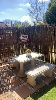 a picnic table with a potted plant on it in front of a fence at 298 on 34th in Pretoria