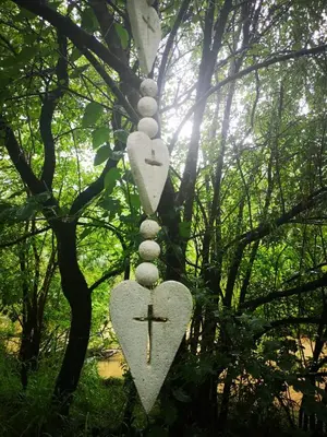 a cross and heart necklace hanging from a tree at Iris Retreat & Island Day Spa in Hartbeespoort