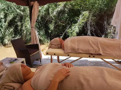 a woman laying on a bed under an umbrella at Iris Retreat & Island Day Spa in Hartbeespoort