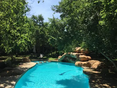 a swimming pool in a yard with a water slide at Iris Retreat & Island Day Spa in Hartbeespoort