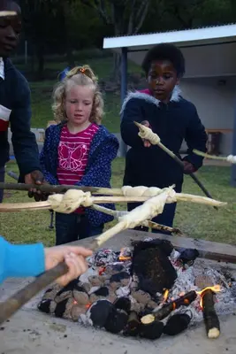 a group of children standing around a fire at Madi a Thavha Mountain Lodge in Louis Trichardt