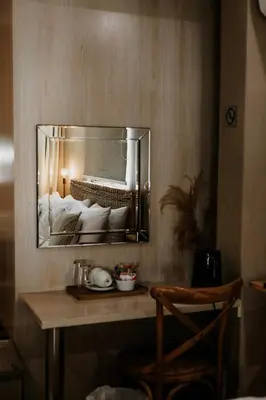 a mirror hanging on a wall in a bedroom at Lighthouse Guesthouse & Cafe in Groblersdal