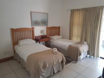 a hotel room with two beds and a window at Homestead Lake Cottage in Benoni