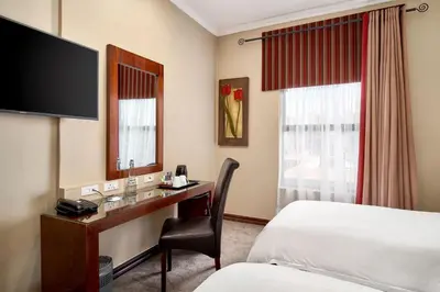 a hotel room with a desk and a bed at Protea Hotel by Marriott Pretoria Hatfield in Pretoria