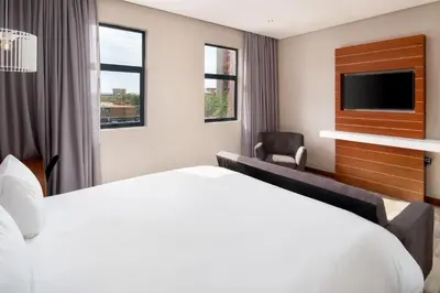 a hotel room with a bed and a tv at Protea Hotel by Marriott Pretoria Hatfield in Pretoria