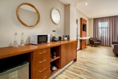 a hotel room with a tv and a mirror at Protea Hotel by Marriott Pretoria Hatfield in Pretoria