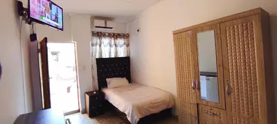 a small bedroom with a small bed and a mirror at Sir Pinto Guesthouse in Witbank