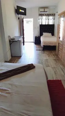 a bedroom with two beds in a room with a door at Sir Pinto Guesthouse in Witbank