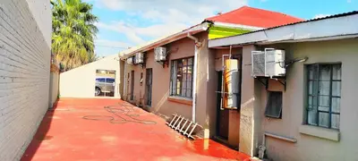 a building with a red sidewalk next to a building at Sir Pinto Guesthouse in Witbank