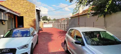 two white cars parked next to a building at Sir Pinto Guesthouse in Witbank