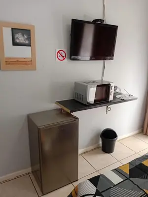 a microwave sitting on a shelf in a kitchen at Minco Guesthouse in Kempton Park