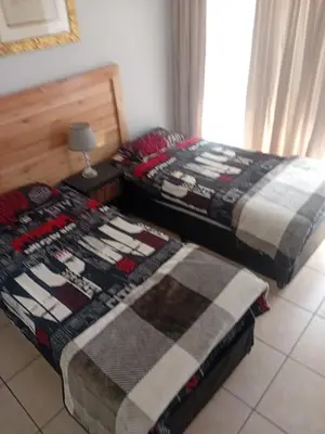 two beds sitting next to each other in a room at Minco Guesthouse in Kempton Park