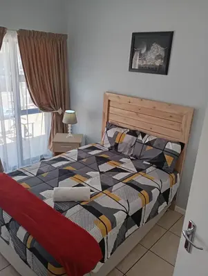 a bedroom with a bed with a colorful comforter at Minco Guesthouse in Kempton Park
