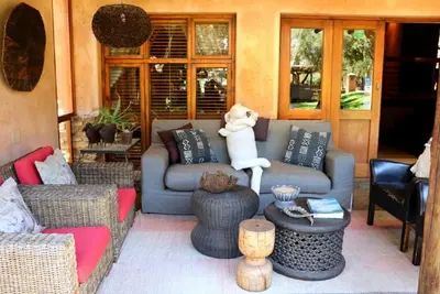a living room with a couch and a teddy bear sitting on top at Sherewood Lodge in Pretoria