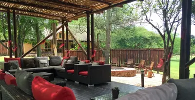 a patio with couches and a fire pit at Sherewood Lodge in Pretoria