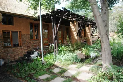 a brick house with a wooden pergola at Sherewood Lodge in Pretoria