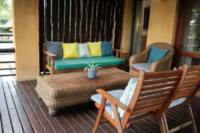 a porch with two chairs and a table and a couch at Sherewood Lodge in Pretoria