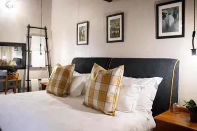 a bedroom with a bed with four pillows on it at Sherewood Lodge in Pretoria