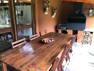 a wooden table with chairs and a bowl of fruit on it at Big 
