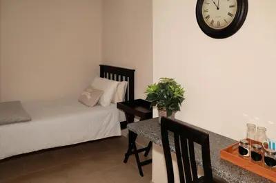 a bedroom with a bed and a table with a clock on the wall at Big 