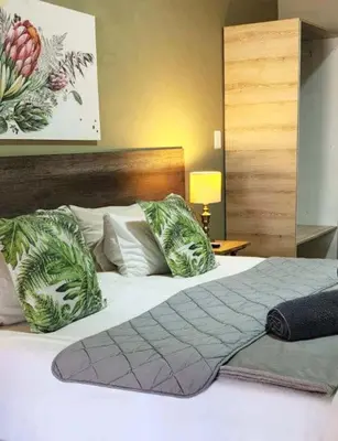 a bedroom with a white bed with green pillows at Big 