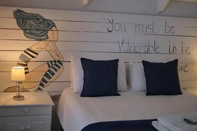 a bedroom with a bed with a sign on the wall at Be Our Guest Self Catering in Nelspruit