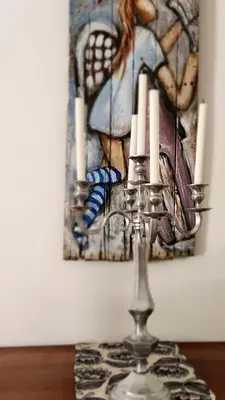 a candle holder on a table in front of a painting at Be Our Guest Self Catering in Nelspruit