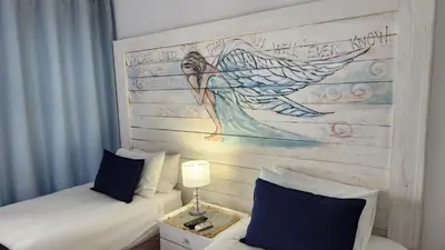 a bedroom with two beds and a painting on the wall at Be Our Guest Self Catering in Nelspruit